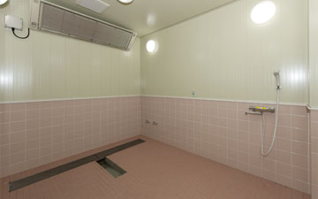 ピンク色のタイルで施工された共同浴場